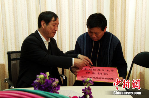 4月2日，专程前来北京探望的中南财经政法大学党委副书记齐文远（左）将全校师生的心意交给徐敏的父亲。